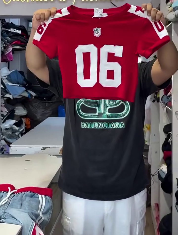 Vibrant Red Crop Top with Number "76" Athletic Print Paired with Light-Wash Denim Pants Featuring Bold Red Side Stripe Panels and Typographic Lettering